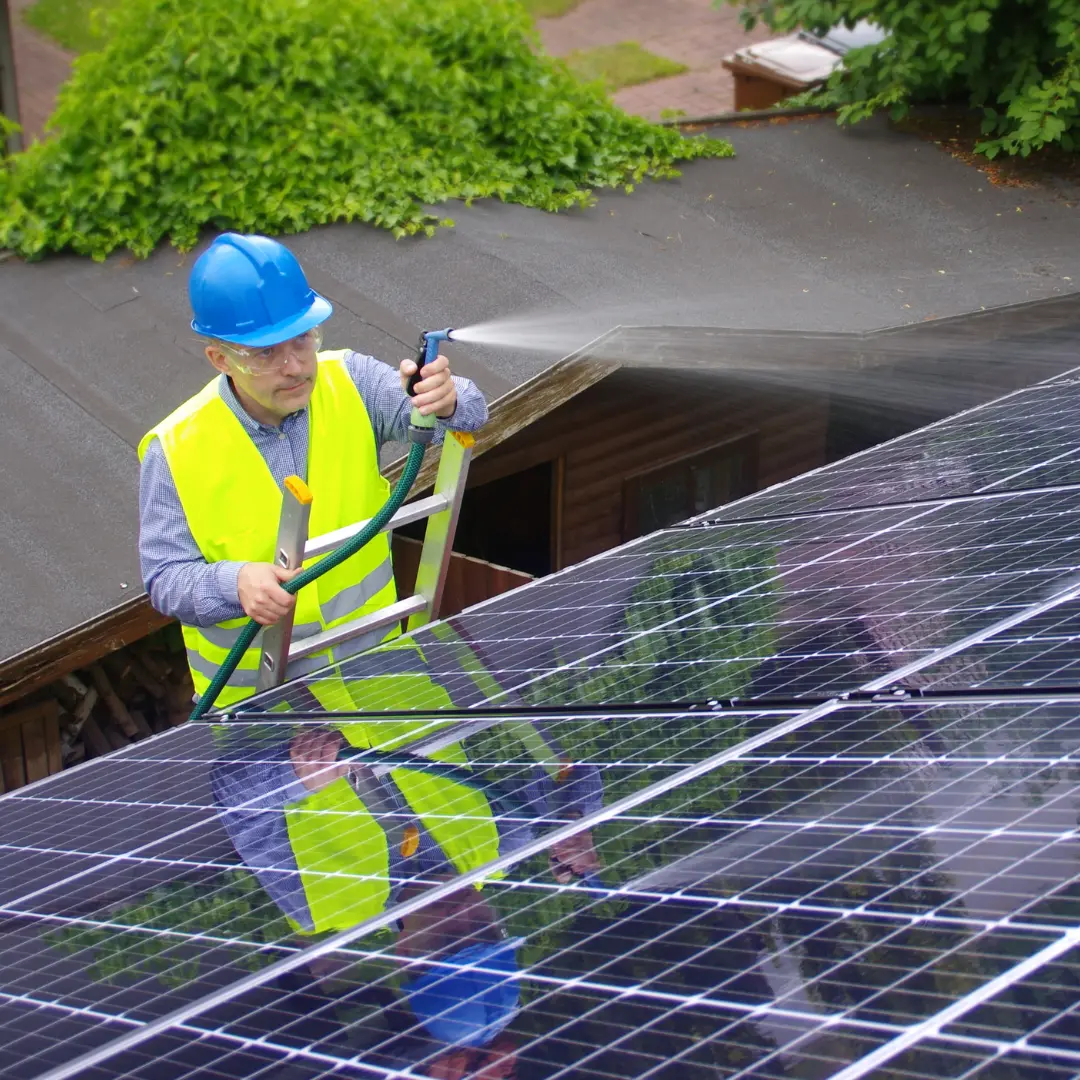Person cleaning solar panels as part of regular solar panel maintenance